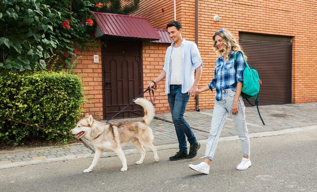 happy-young-stylish-couple-walking-with-dog-street